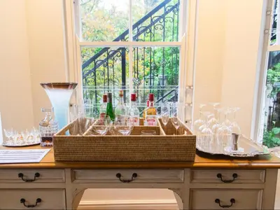 a sink with bottles and glasses on a table at Le Petit Paris in Franschhoek