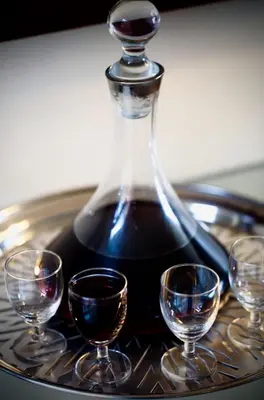 a bottle of wine with three wine glasses on a table at Cinnamon House Bed & Breakfast in Cape Town