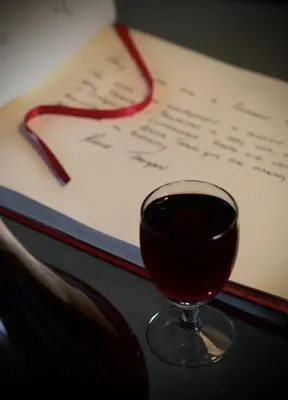 a glass of wine sitting next to a book at Cinnamon House Bed & Breakfast in Cape Town