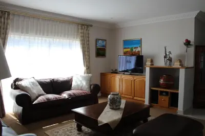 a living room with a couch and a tv at Cinnamon House Bed & Breakfast in Cape Town