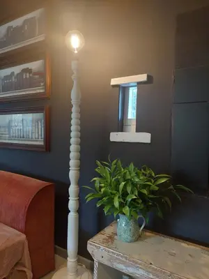 a living room with a lamp and a plant on a table at Kimi's Cottage in Simondium