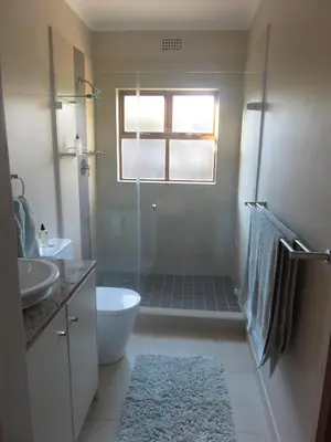 a bathroom with a shower and a toilet and a sink at Waves Echo in Bloubergstrand