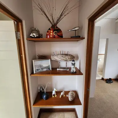 a room with wooden shelves and a mirror at Riverside 18 in Hermanus