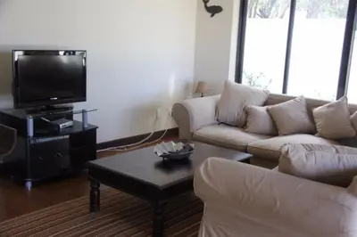 a living room with a couch and a tv at Riverside 18 in Hermanus