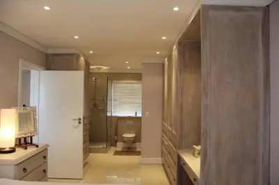 a bathroom with a toilet and a television in it at Whale Rock 54 in Hermanus