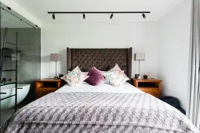 a bedroom with a large bed with purple pillows at De Zalze Lodge in Stellenbosch