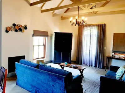 a living room with a blue couch and a table at De Zalze Lodge in Stellenbosch