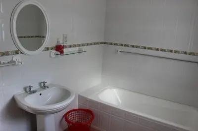 a white bathroom with a sink and a mirror at Sit-en-Kyk in Hermanus