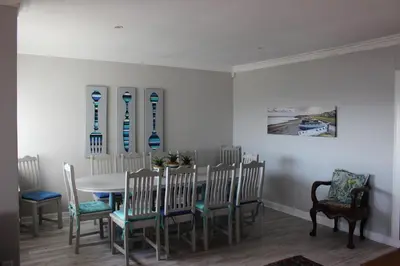 a dining room with a table and chairs at Sit-en-Kyk in Hermanus