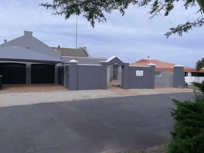 a house with a purple fence and a driveway at Sit-en-Kyk in Hermanus