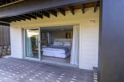 a bedroom on a porch with a bed on a patio at Pringle Bay Villa in Pringle Bay