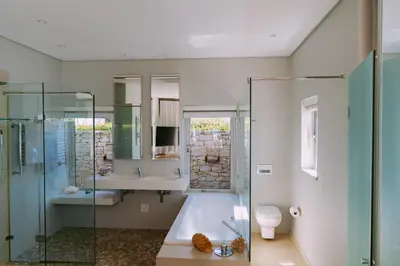 a bathroom with a tub and a sink and a toilet at Pringle Bay Villa in Pringle Bay