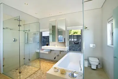 a bathroom with a tub and a glass shower at Pringle Bay Villa in Pringle Bay