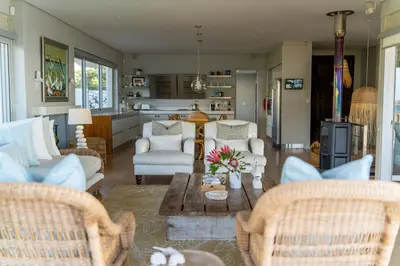 a living room with chairs and a table and a kitchen at Pringle Bay Villa in Pringle Bay