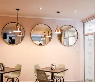 a dining room with three mirrors on the wall at New National Hotel and Conference in Parow