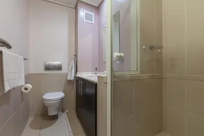 a bathroom with a shower and a toilet and a sink at Lagoon Beach 136A by CTHA in Cape Town