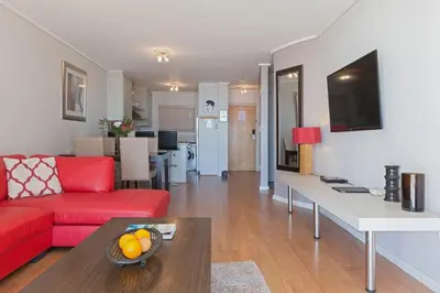 a living room with a red couch and a table at Lagoon Beach 136A by CTHA in Cape Town