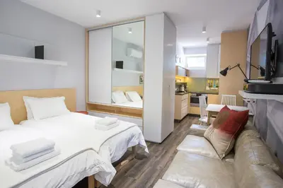 a bedroom with a bed and a living room at Laanhof Studios in Stellenbosch