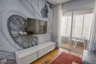 a living room with a tv on a wall at Laanhof Studios in Stellenbosch