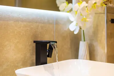 a bathroom sink with water running from a faucet at Knightsbridge Luxury Suite in Century City by CTHA in Cape Town