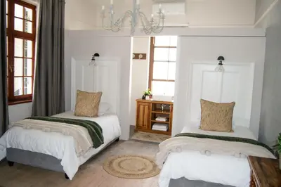 a bedroom with two beds and a chandelier at Madeliefie Guest Accommodation in Paarl