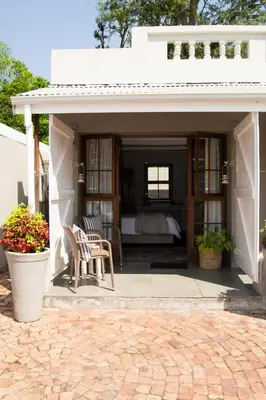 a pavilion with a bed and a table and chairs at Madeliefie Guest Accommodation in Paarl