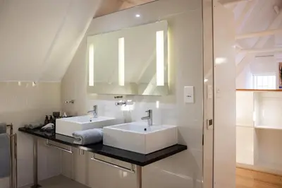 a bathroom with two sinks and a mirror at Allèe Bleue Wine Estate in Simondium