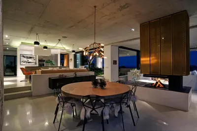 a dining room and kitchen with a table and chairs at Restio River House in Pringle Bay