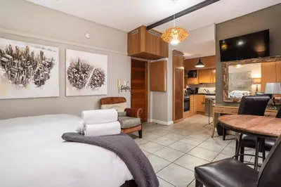 a bedroom with a bed and a dining room at Avemore Eikehoff No 24 full back up power in Stellenbosch