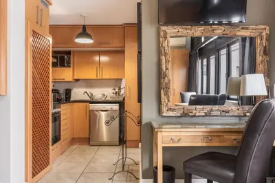 a kitchen with a mirror and a table with a chair at Avemore Eikehoff No 24 full back up power in Stellenbosch