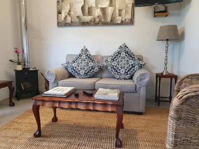a living room with a couch and a coffee table at Paul Wallace Wines & Cottages in Elgin