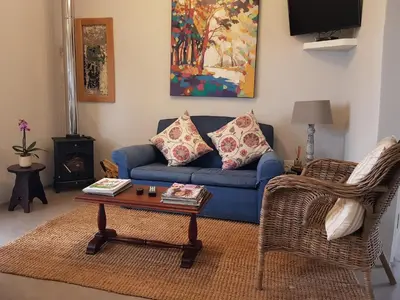 a living room with a blue couch and a coffee table at Paul Wallace Wines & Cottages in Elgin