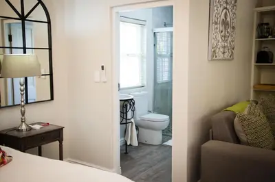 a bedroom with a bathroom with a toilet and a mirror at Afrika-Pearl in Paarl