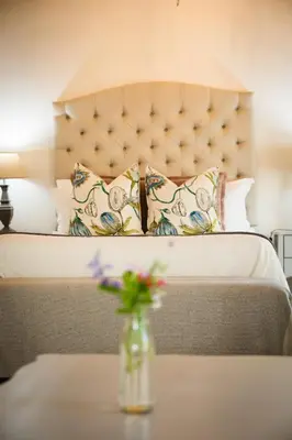 a bedroom with a bed with a vase of flowers on a table at Afrika-Pearl in Paarl