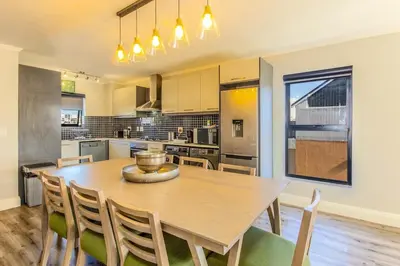 a large kitchen with a wooden table and chairs at Quayside 301 by CTHA in Cape Town