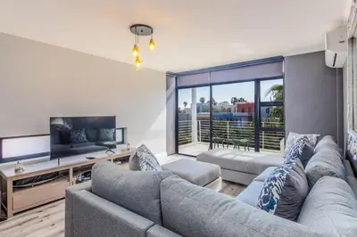 a living room with a couch and a tv at Quayside 301 by CTHA in Cape Town