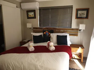 a bedroom with a bed with two stuffed animals on it at Dilisca Guesthouse in Durbanville