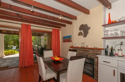 a kitchen and dining room with a table and chairs at Just Unwind in Somerset West