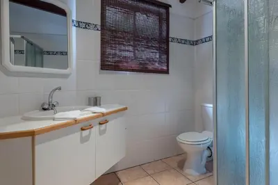 a bathroom with a toilet and a sink and a shower at Just Unwind in Somerset West