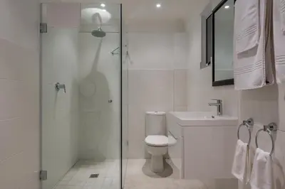 a bathroom with a toilet and a glass shower at Just Unwind in Somerset West