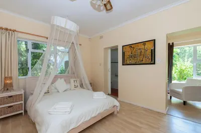 a bedroom with a bed with a mosquito net at Just Unwind in Somerset West