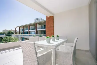 a white table and chairs on a balcony at Superior Apartment Mayfair in Cape Town