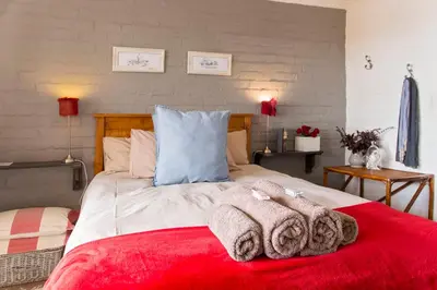 a bedroom with a large bed with towels on it at Waterside on Le Bonheur in Simondium