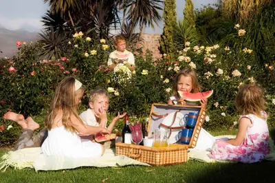a group of children sitting on the grass eating watermelon at Waterside on Le Bonheur in Simondium