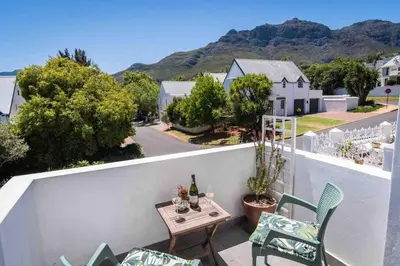 a patio with a table and chairs on a balcony at Anesta House in Stellenbosch