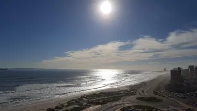a view of a beach with the sun and the ocean at Portico 802 in Bloubergstrand