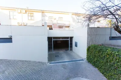 a white building with a garage in front of it at Vino Self Catering Apartment in Stellenbosch