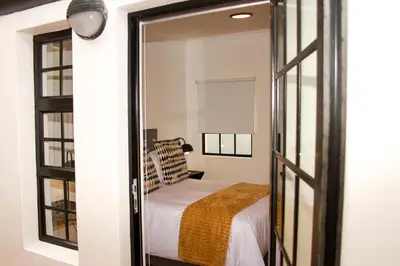 a bedroom with a bed and a mirror at Hermanus Champagne Accommodation in Hermanus