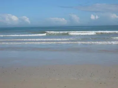 a sandy beach with waves in the ocean at Emerald Bay in Strand