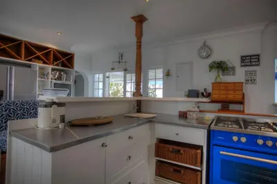 a kitchen with white cabinets and a blue stove at Our Hermanus House in Hermanus